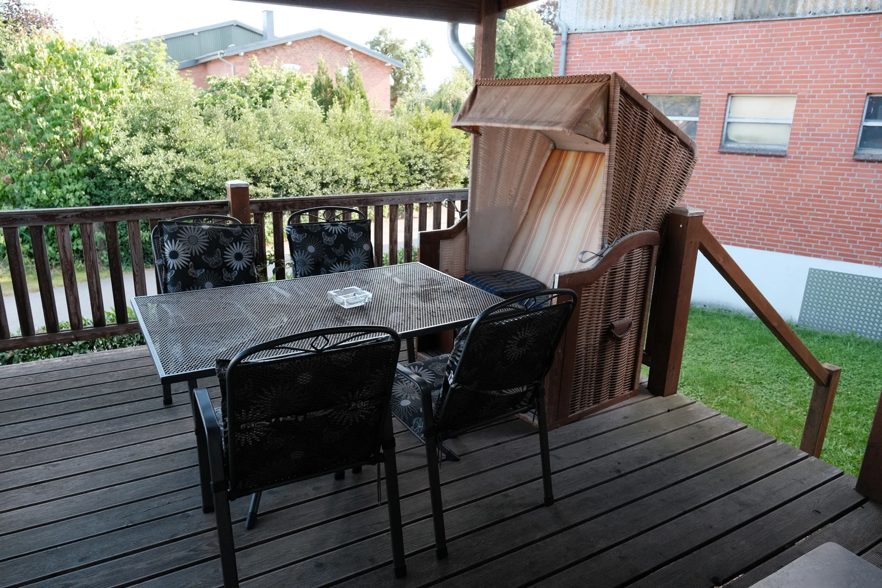 Überdachte Terrasse mit Tisch und Sitzplätzen